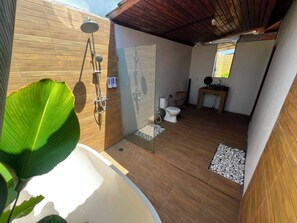 Un baño moderno con ducha envuelta en cristal, inodoro y lavamanos.