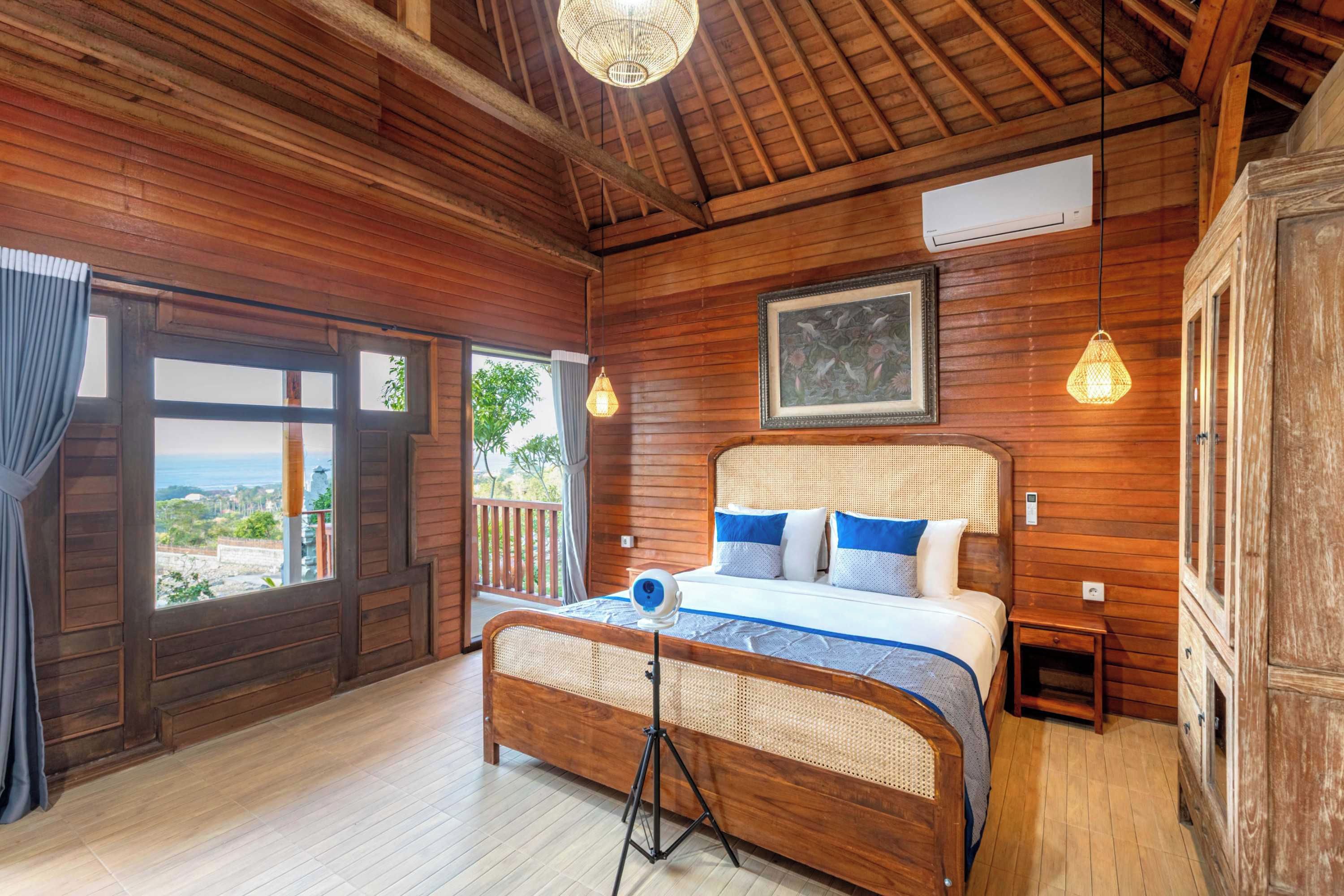 Una habitación de madera con una cama, un ventanal y vistas.