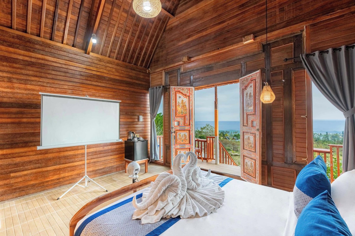 Una habitación de madera con una cama, una pizarra y vistas al exterior.