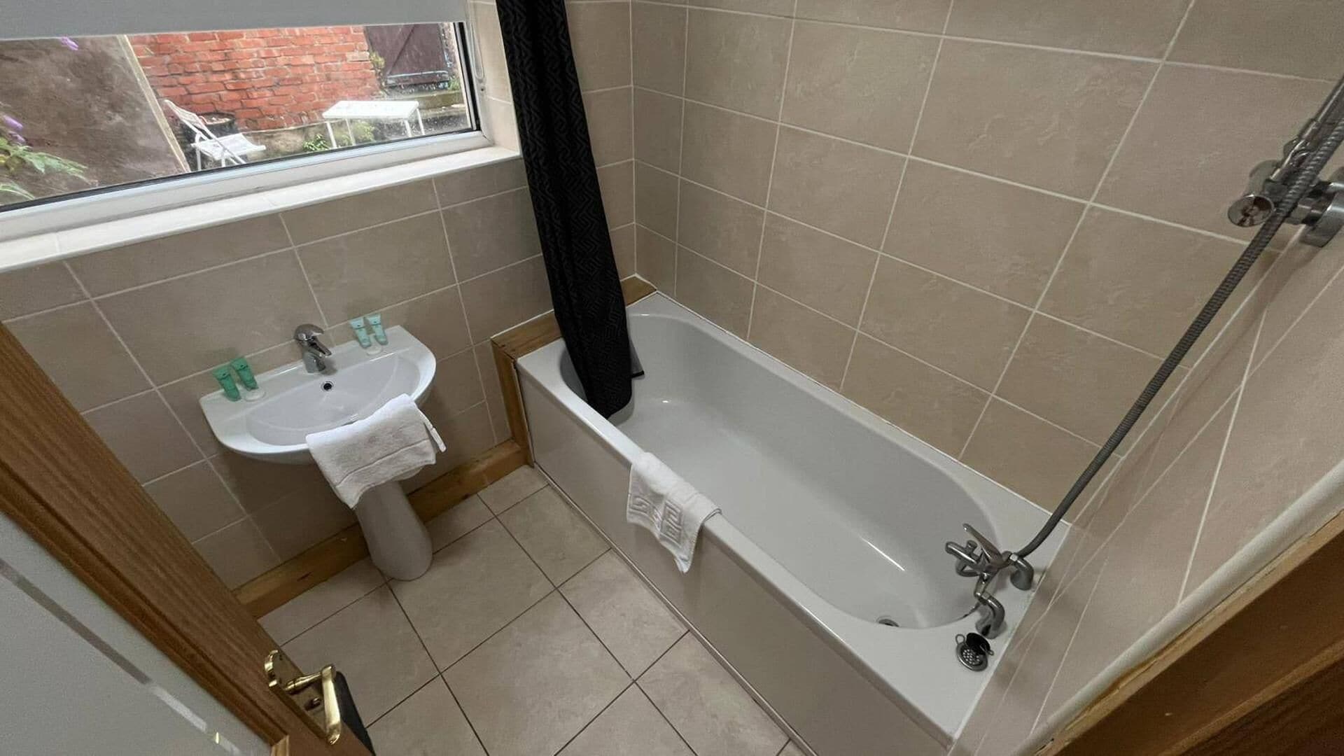 A bathroom with a bathtub, a sink, and a window.