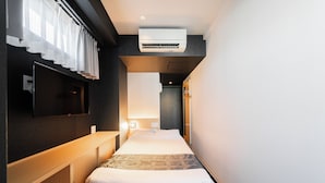 A hotel room with a bed, a desk, a TV, and an air conditioning unit. - FL Residence Jingugyoen VI (Shibuya City)