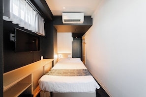 A hotel room with a bed, a desk, a TV, and an air conditioning unit. - FL Residence Jingugyoen VI (Shibuya City)