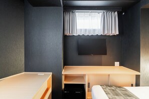 A compact hotel room with a single bed, a desk, and a television mounted on the wall. - FL Residence Jingugyoen VI (Shibuya City)