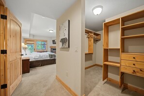 A bedroom with a bed, a bedside table, a window, and a fireplace. - Wy’East Condo 104 at South Grand Lodge | Dog Friendly, Best Mt. Hood View (Government Camp)