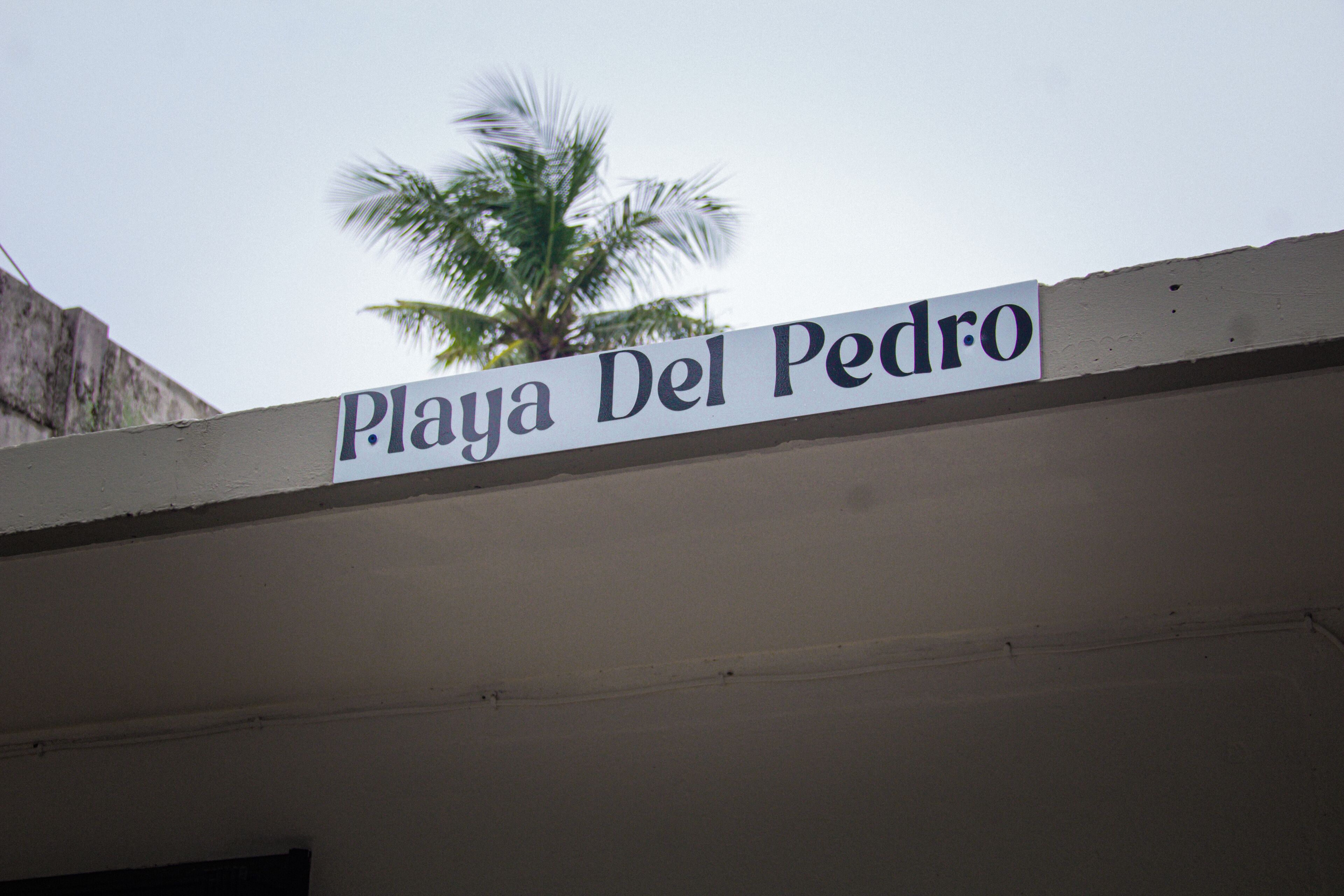 Ein Schild mit dem Schriftzug 'Playa Del Pedro', das einen Ort kennzeichnet.