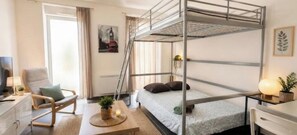 A bunk bed room with a desk, chair, and a plant. - Apartment with Free Parking + Air Conditioning (Avignon)