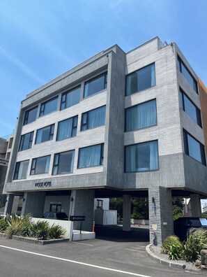 Un moderno edificio de hotel con fachada plana, múltiples ventanas y una entrada visible.
