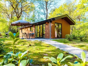 A log cabin with a patio and outdoor seating area. - Holiday Home for Four in Ruinen (Ruinen)