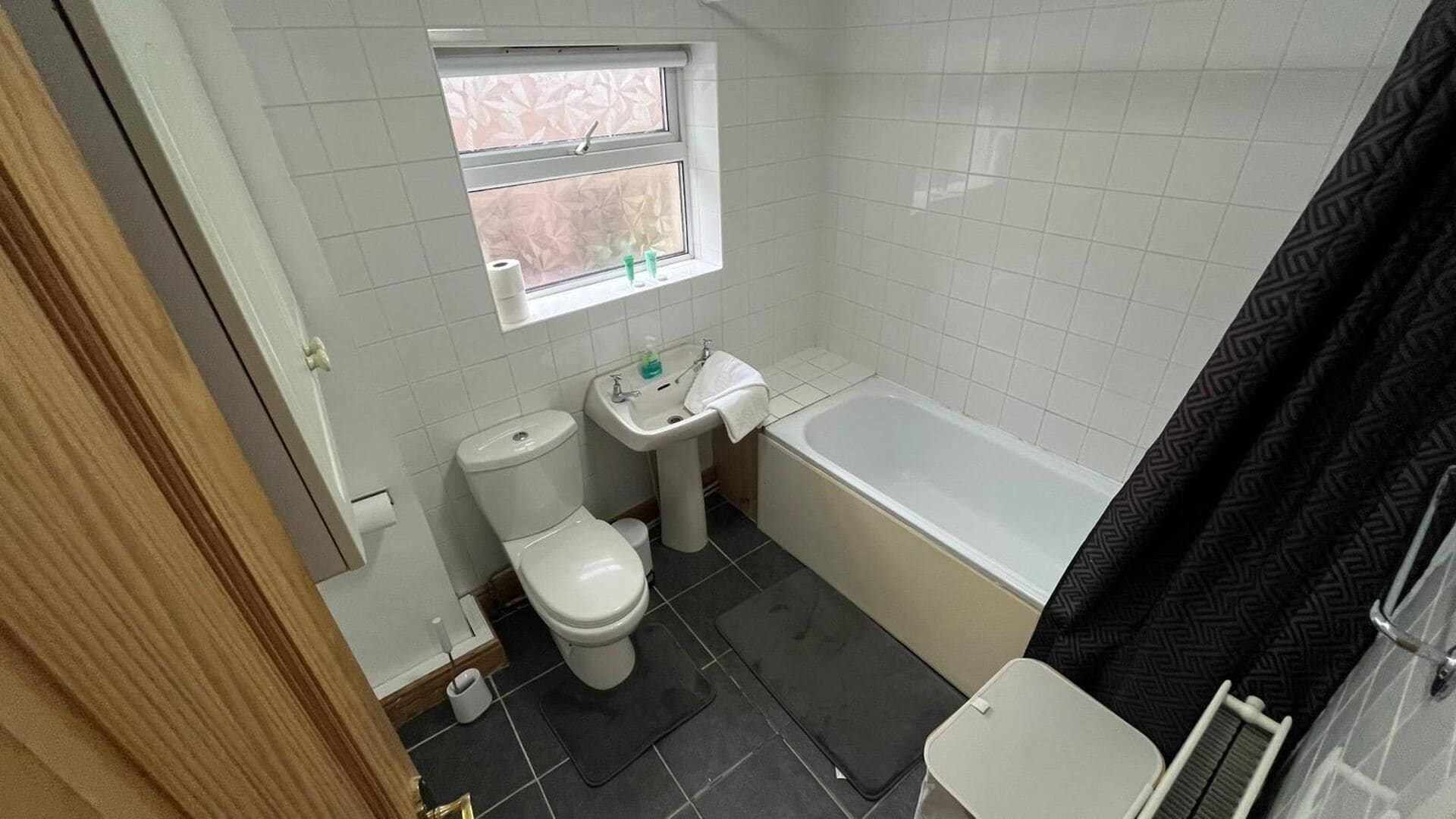 Un baño pequeño con inodoro, lavamanos y bañera.