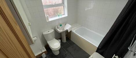 Un baño pequeño con inodoro, lavamanos y bañera.
