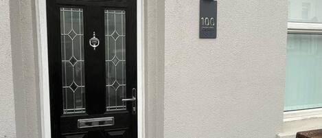 A black door with a white frame and a number plate indicating '100'.