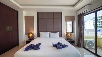 A hotel room with a large bed, two bedside tables, a headboard, and a view of buildings through the window.