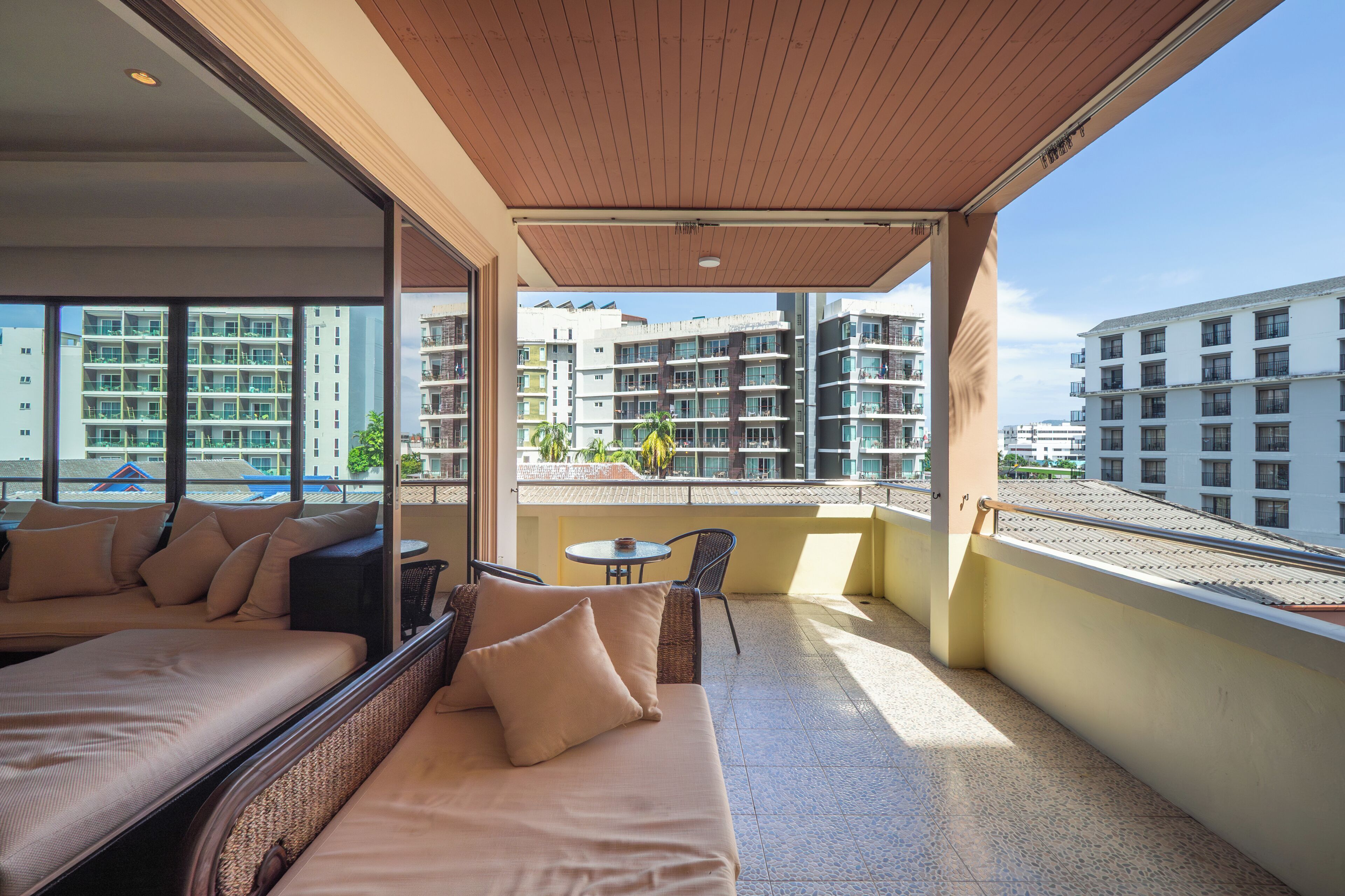 A balcony with a sofa, a small table, and a chair.