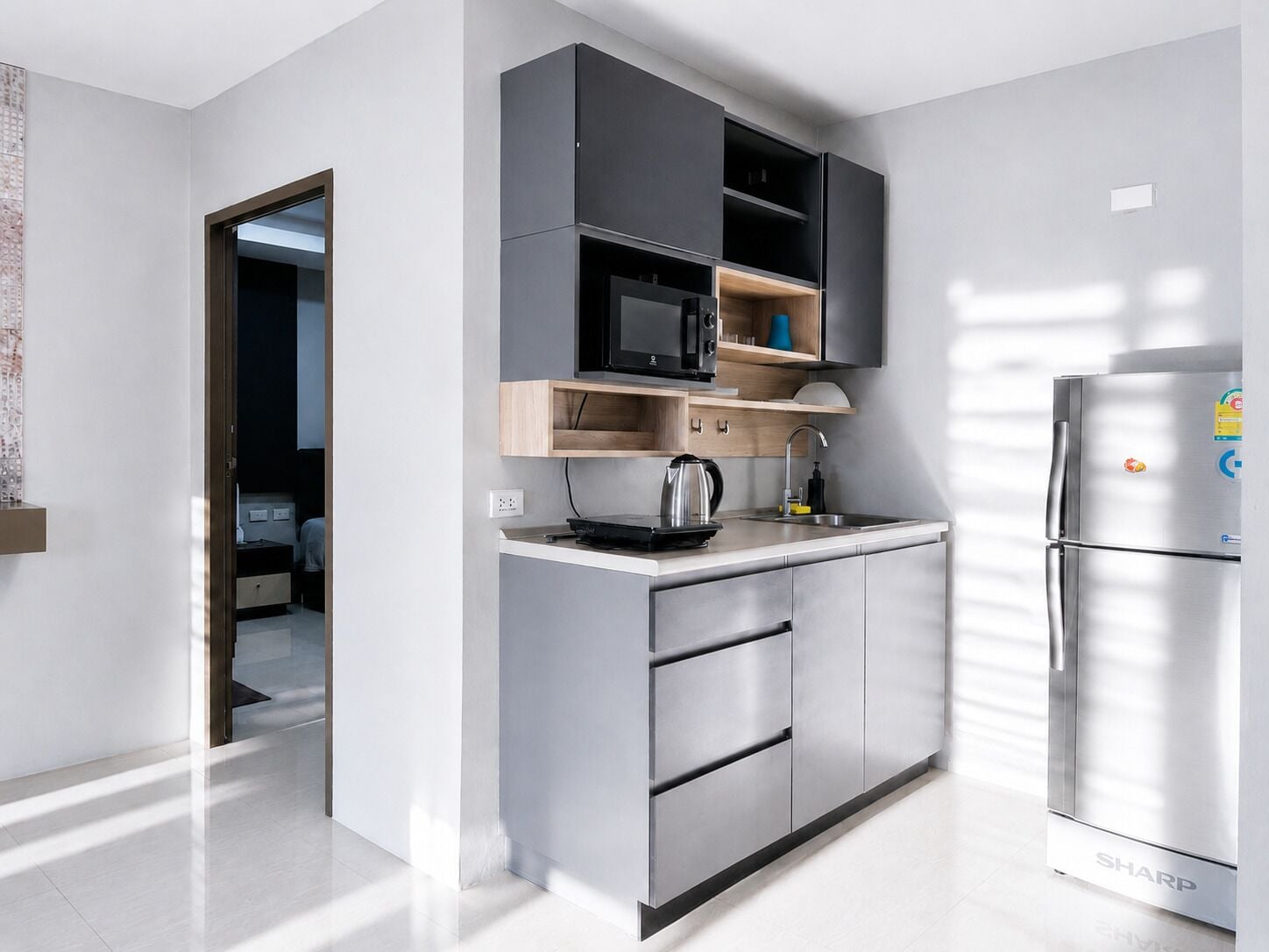 A modern kitchen with built-in appliances, a stainless steel refrigerator, and a minimalist design.