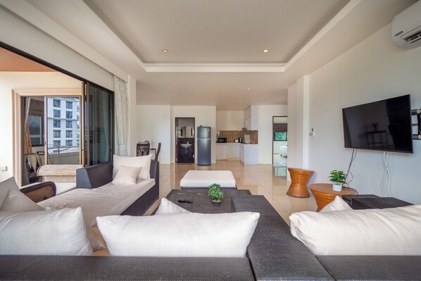 A modern living room with a sofa set, a coffee table, and a television.