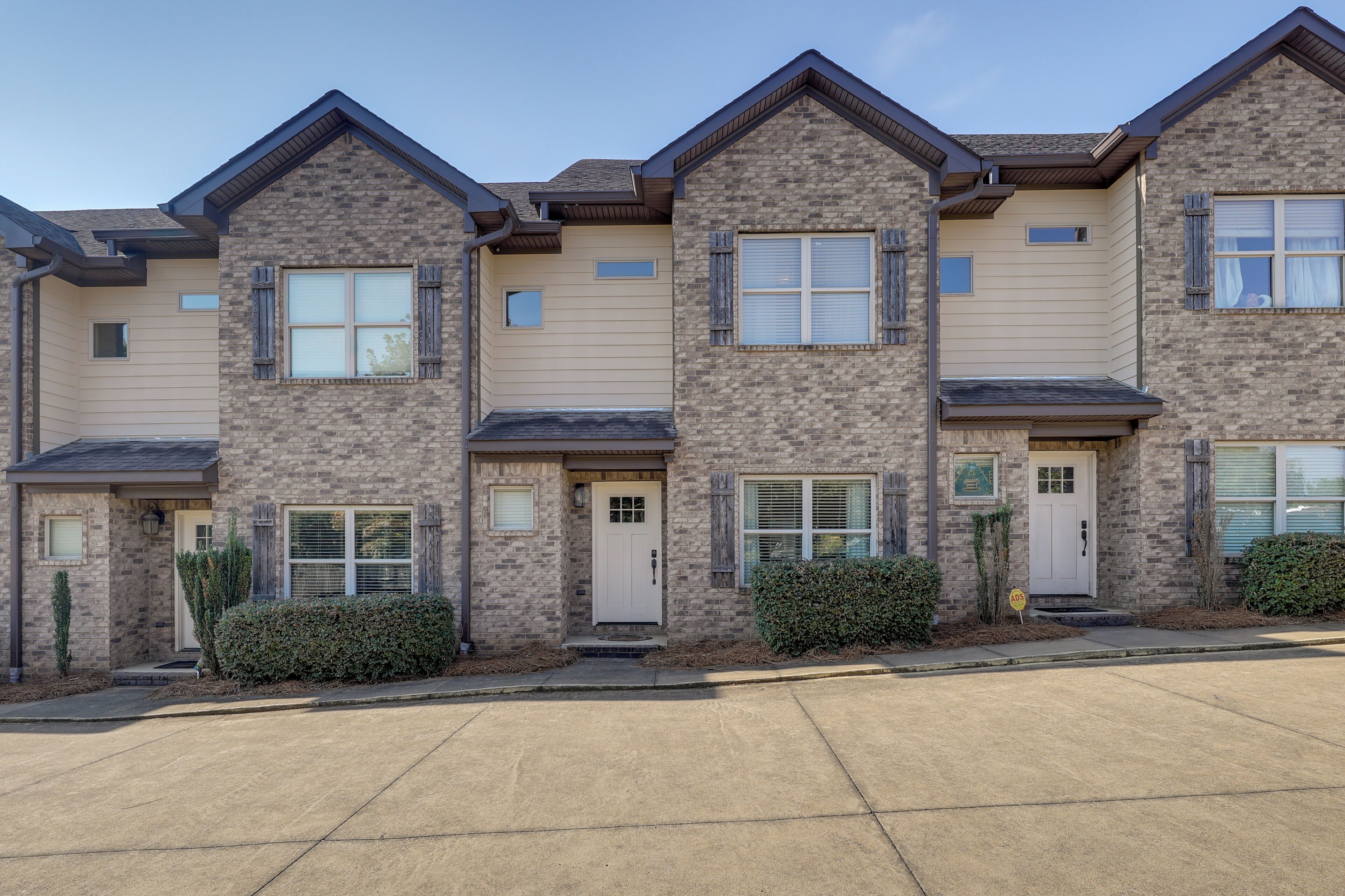 A row of townhouses with brick facades, front doors, and small windows.