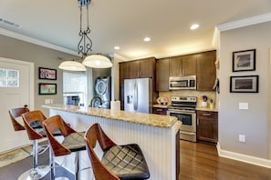A kitchen with a central island, bar stools, a refrigerator, an oven, and a microwave. - Walk to Campus! Auburn Escape w/ Grill (Auburn)