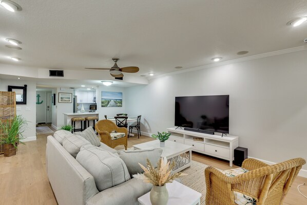 Una sala de estar moderna con un sofá, televisor y comedor.