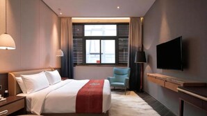 A modern hotel room with a bed, a flat-screen TV, a chair, and a window with curtains. - Nanxianglou Art Hotel (Shenzhen)