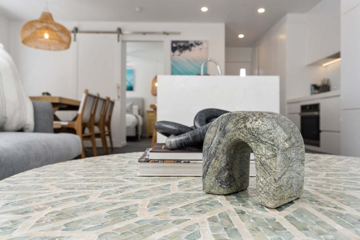 A modern interior with a round table, a sofa, and a dining area.