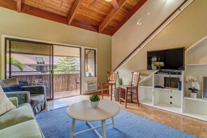 A living room with a sofa, a coffee table, a TV, and a sliding glass door leading to a balcony. - Family Getaway 2BD w AC Pool Beach - Kihei Resort 202 (Kihei)