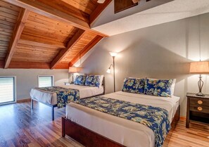 A bedroom with two beds, wooden beams, a sloped ceiling, and a nightstand with a lamp. - Family Getaway 2BD w AC Pool Beach - Kihei Resort 202 (Kihei)