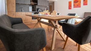Una cocina moderna con armarios de madera, una mesa de comedor y sillas negras.