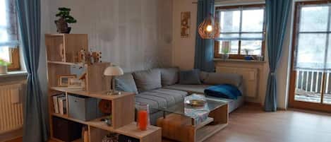 A modern living room with a sofa, coffee table, and shelves.