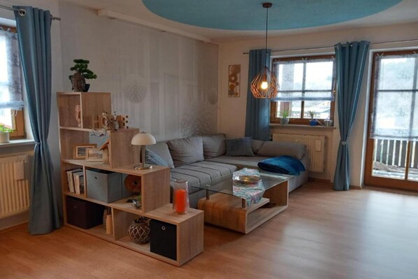 Een moderne woonkamer met een bank, salontafel en boekenkasten.