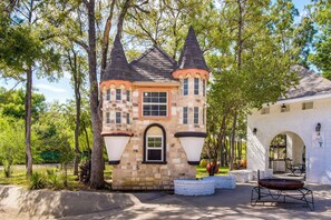 A stone castle-like structure with a central tower, a small window, and a door.