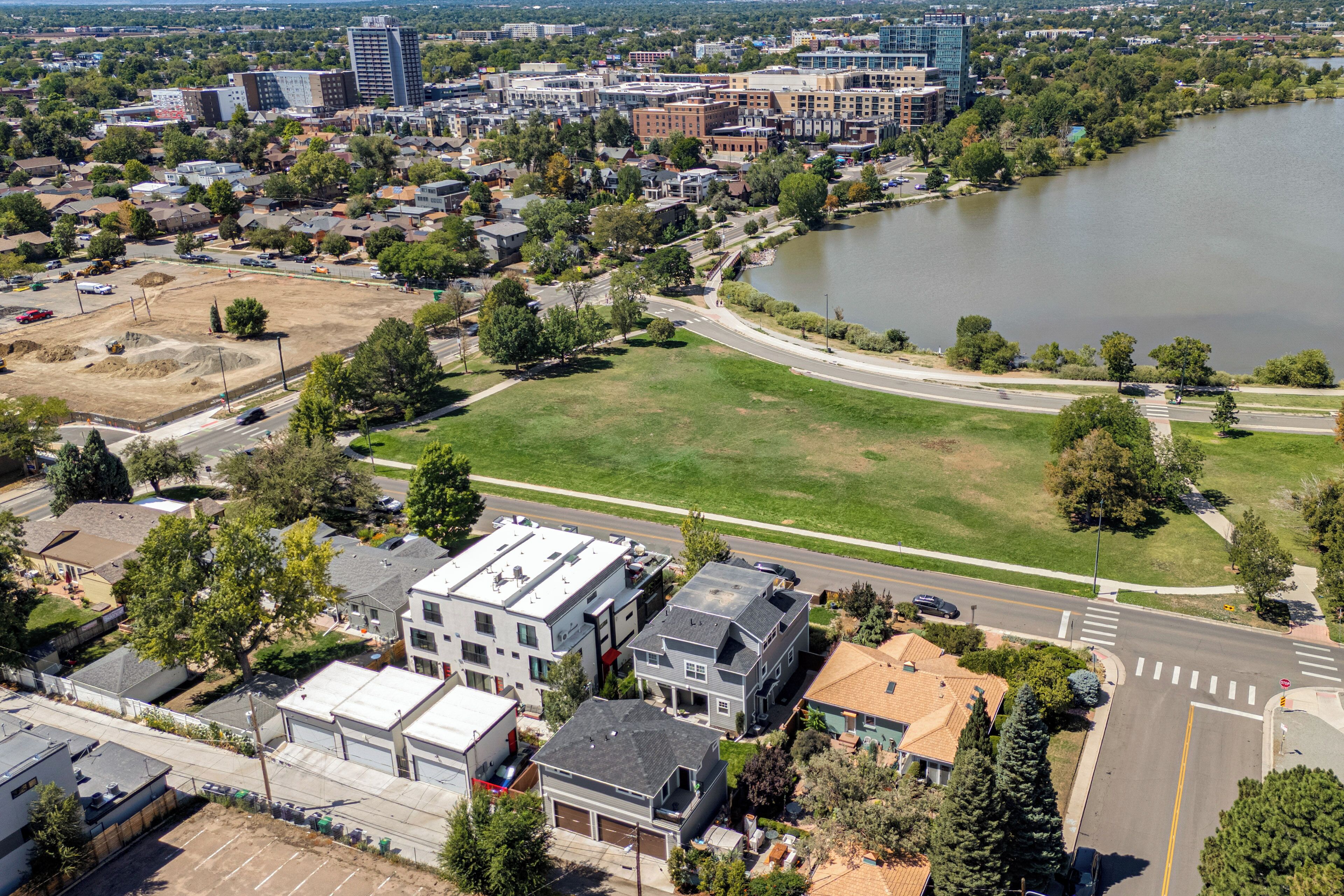 Ett flygbildsbild av ett bostadsområde med hus, en stor, öppen gräsyta och en flod.