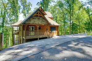A log cabin with a porch, a chimney, and a fenced yard. - Mtn Views, Hot Tub, & Theater! Sevierville Gem (Sevierville)