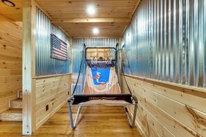A basketball court with a net, a basketball hoop, and an American flag on the wall. - Mtn Views, Hot Tub, & Theater! Sevierville Gem (Sevierville)