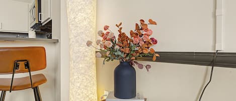 Un bureau orné d’un vase de fleurs, une chaise et deux livres intitulés « L’art de la simplicité » et « Poésie spatiale ».