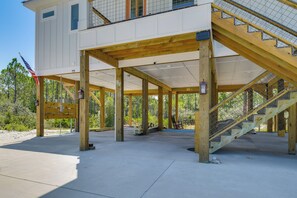 A building under construction with a wooden staircase and a view of the surrounding trees. - Fort Morgan Hideaway Hot Tub | Golf | Beach Access (Gulf Shores)