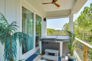A covered outdoor area with a hot tub, seating, and potted plants. - Fort Morgan Hideaway Hot Tub | Golf | Beach Access (Gulf Shores)
