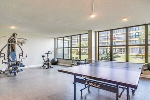 A gym with exercise equipment, a ping pong table, and large windows offering a view of the outside. - 1 Block to Beach! Indian Shores Condo, Pool Access (Indian Shores)