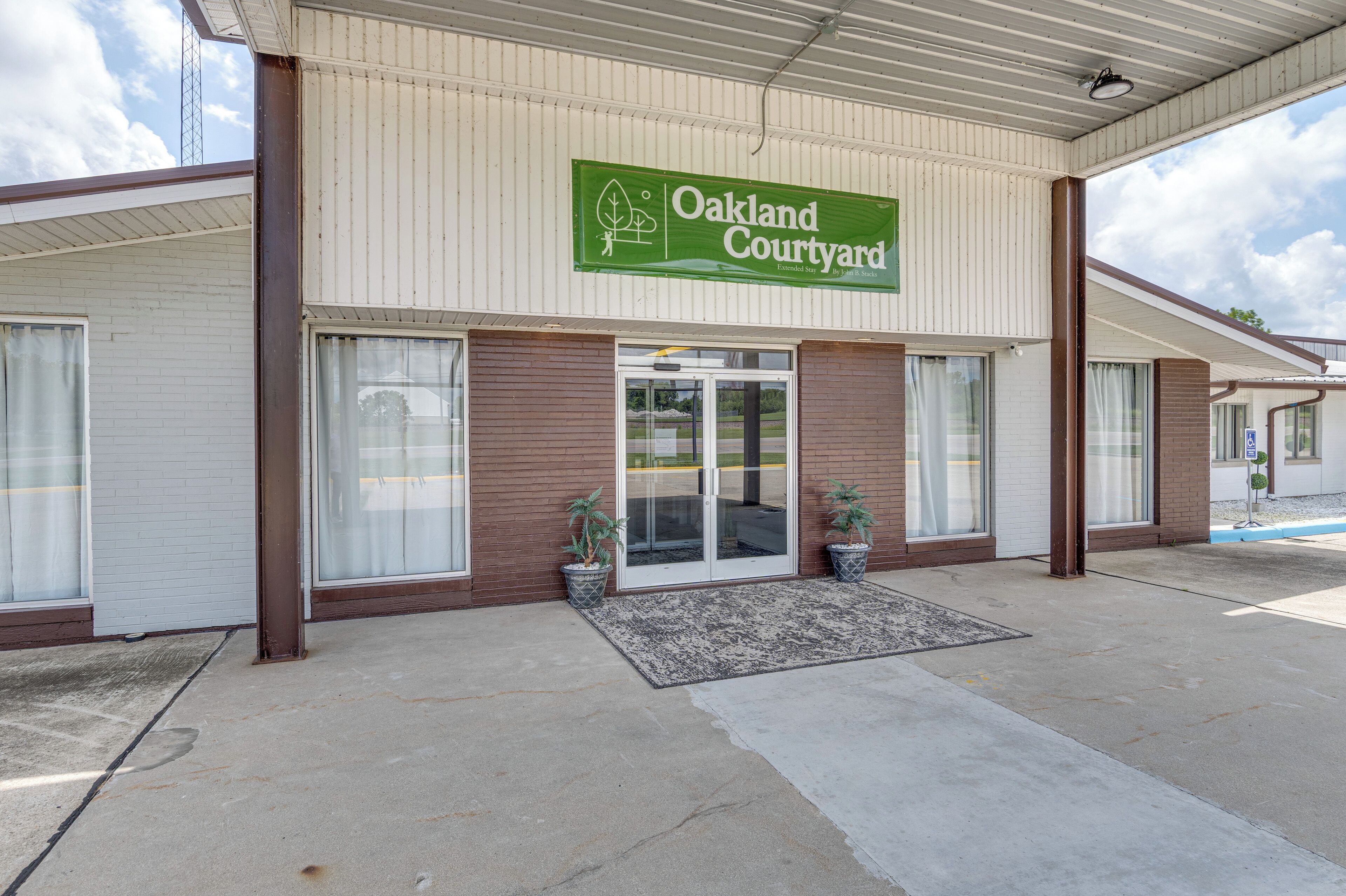 A building with a sign reading 'Oakland Courtyard' and a covered entrance.