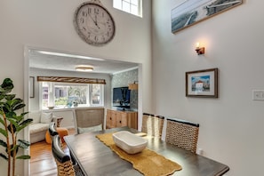 A dining area with a wooden table, chairs, and a large wall clock. - 2 Mi to Atlantic Beach! Family Escape w/ Gas Grill (Morehead City)