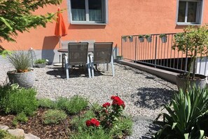 A patio area with a table and chairs, surrounded by gravel and potted plants. - Holiday apartment with 1 bedroom (Gaschurn)