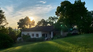 A house with a sloped roof, surrounded by a grassy area and trees. - Pechingorp Guest Room - Tilleul - Shared Pool, Terrace, and Wi-Fi (Le Verdier)