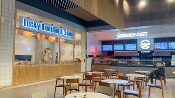 A restaurant interior with a counter, chairs, and tables.
