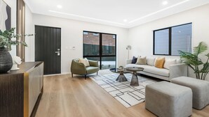 A modern living room with a sofa, armchairs, a coffee table, and a rug. - Airy Howick New Build, Walk to Shops (Auckland)