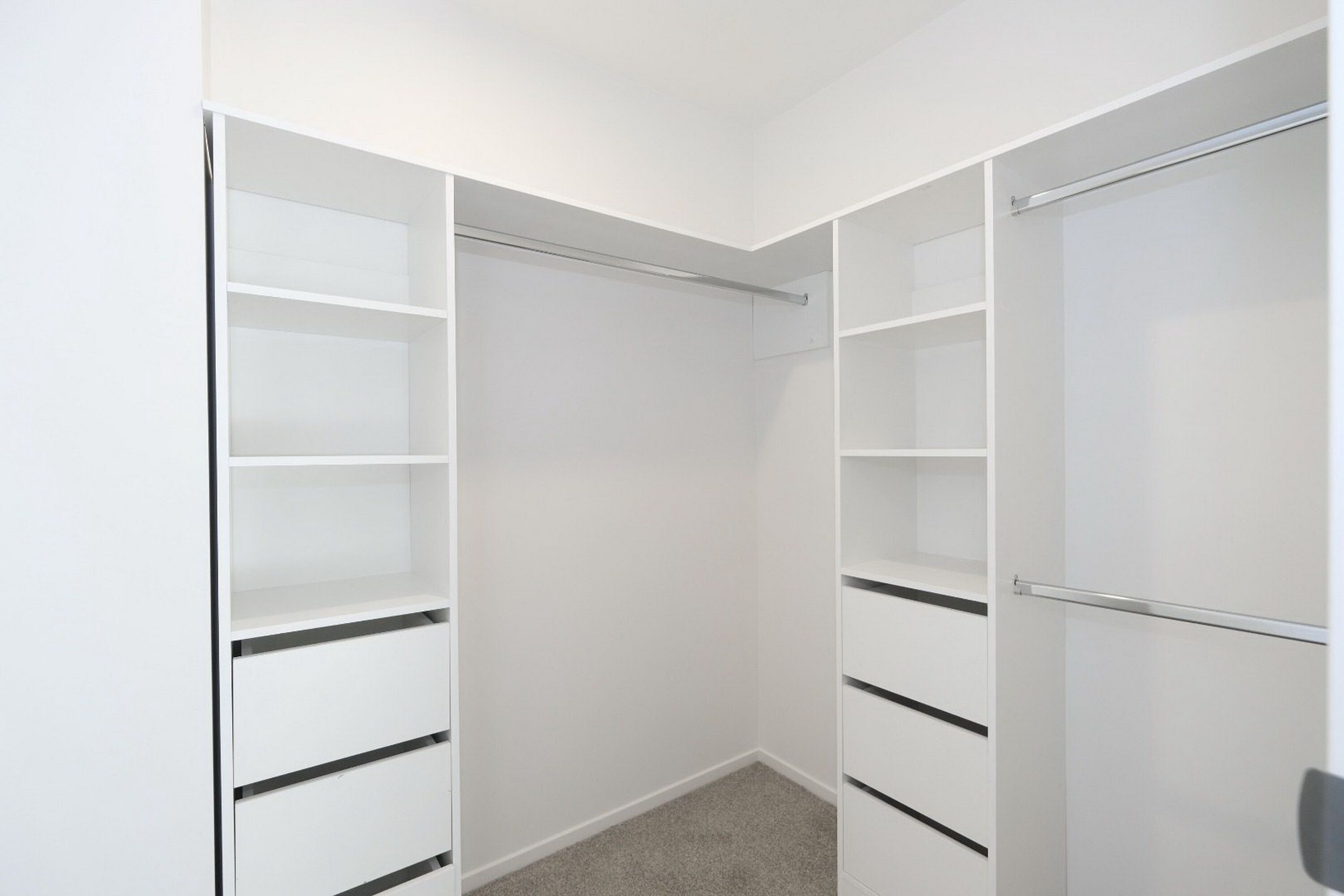 A walk-in closet with multiple shelves and hanging space.