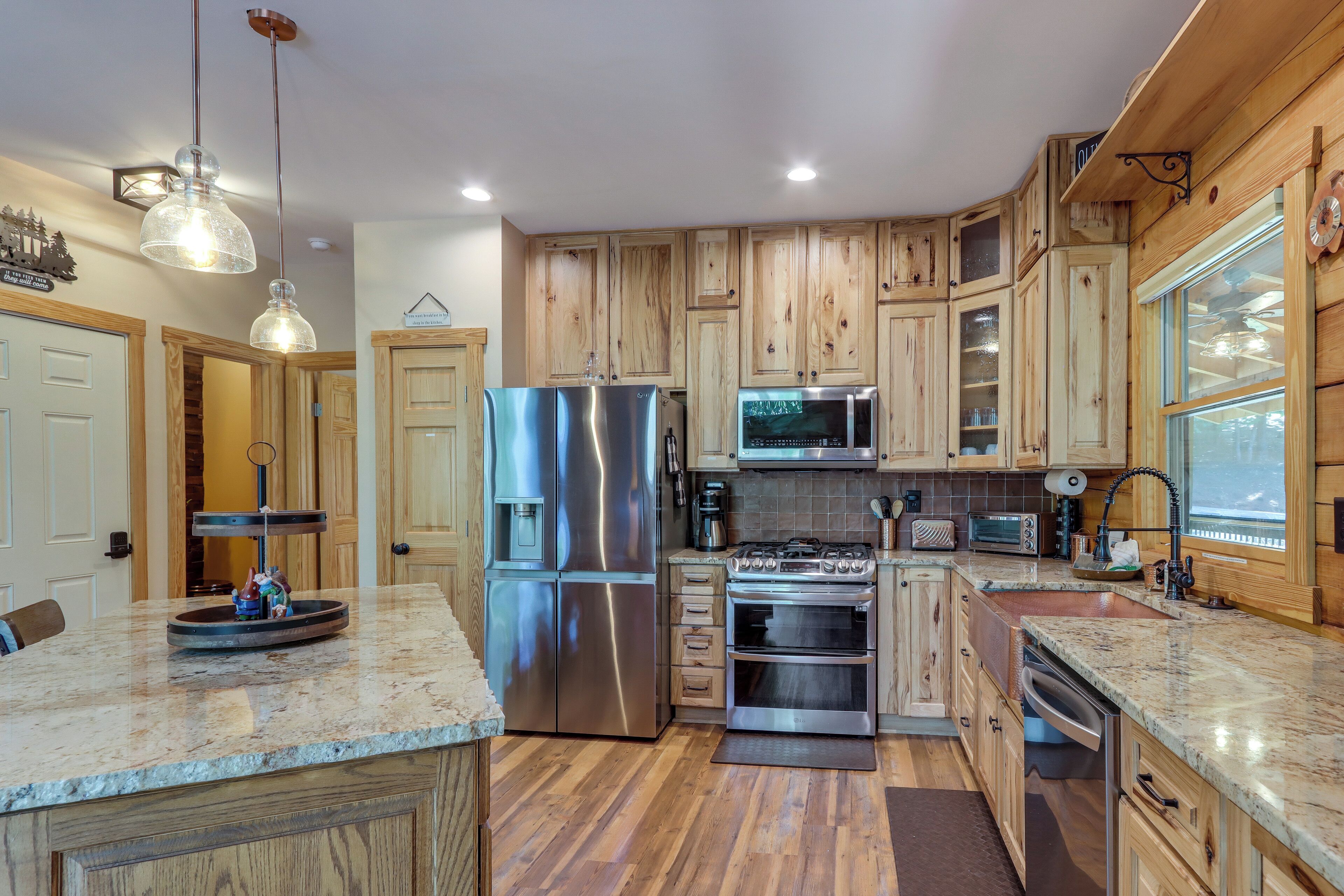 A modern kitchen with wooden cabinets, stainless steel appliances, and a granite countertop.
