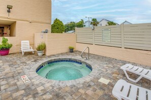 Ein Swimmingpool mit Tiefenmarkierung von 3 Fuß, umgeben von einer gefliesten Terrasse, mit Liegestühlen und Topfpflanzen.