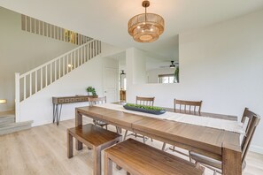 A dining area with a wooden table, benches, and a chandelier. - Golf View, Pool Access! Updated Queen Creek Home (Queen Creek)