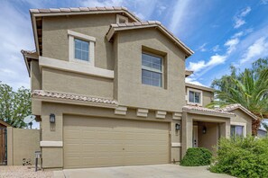 A two-story house with a garage, satellite dish, and a small window. - Golf View, Pool Access! Updated Queen Creek Home (Queen Creek)