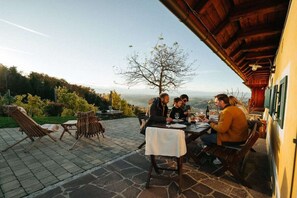 A group of people dining at an outdoor table with a view of the landscape. - Holiday apartment with 1 bedroom (St. Johann)