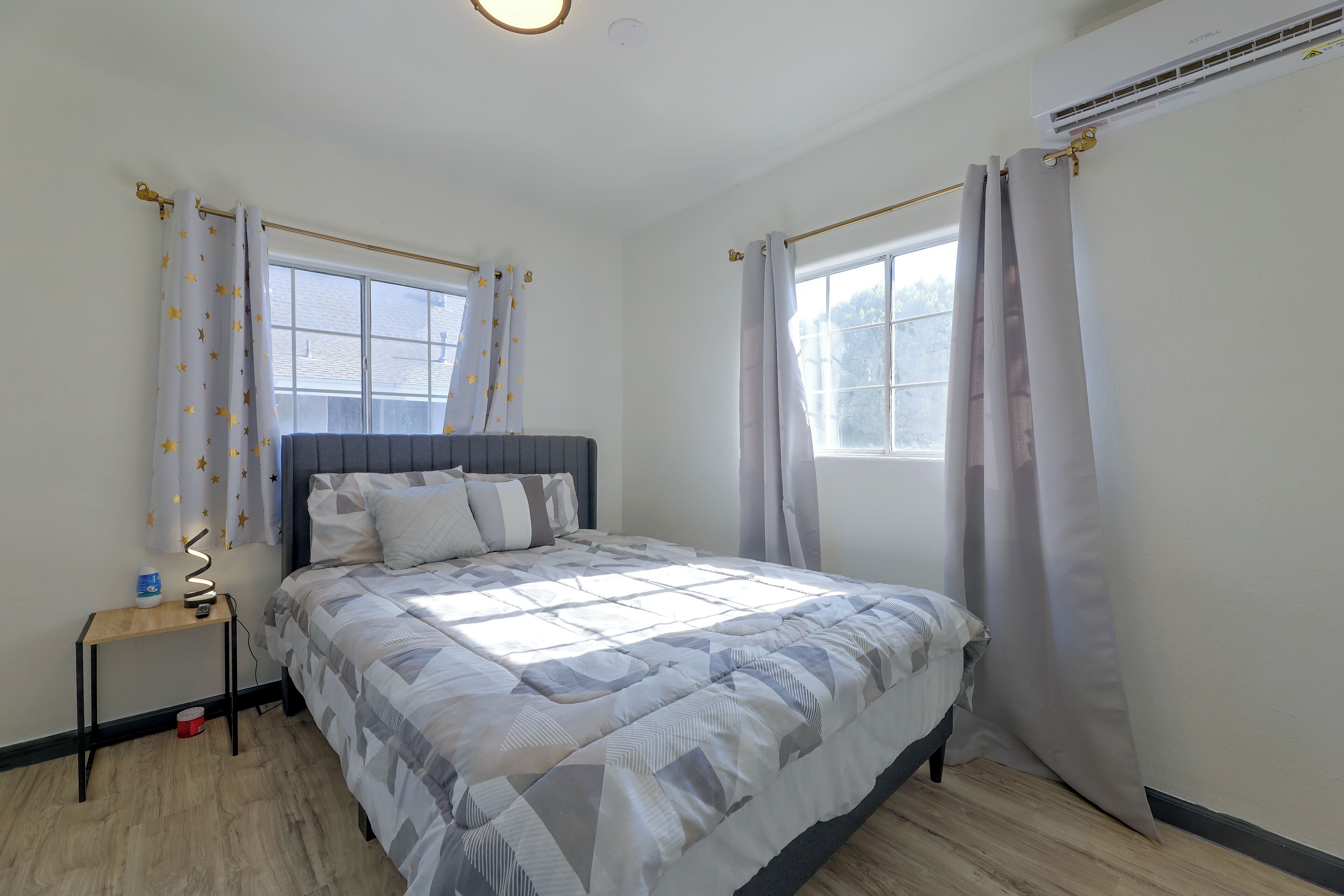 A bedroom with a bed, bedside tables, a window, and curtains.